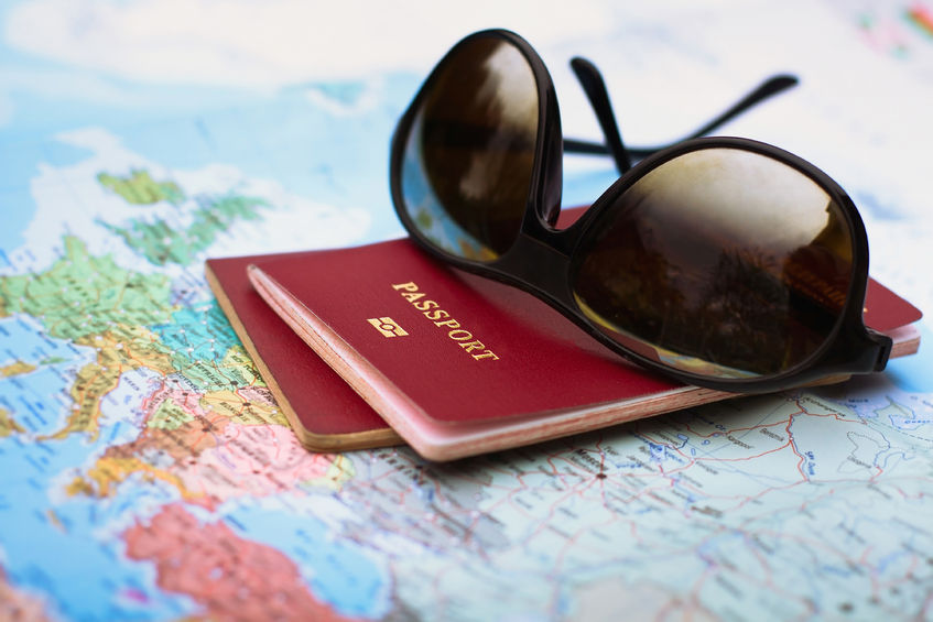 sunglasses and passports sitting on top of a world map