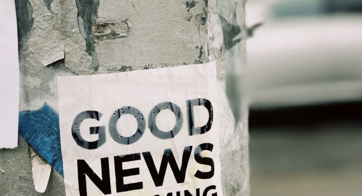 Sign on an electric pole that reads "good news is coming"